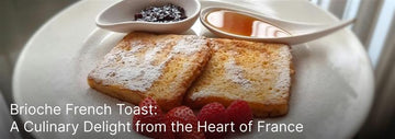 Brioche French toast slices dusted with powdered sugar, served with raspberries, jam, and syrup on a white plate.