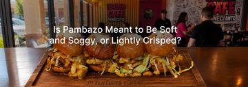 Pambazo sliders with chorizo, potatoes, lettuce, and sauce served on a wooden tray inside Loaded Cafe, with a restaurant interior in the background.