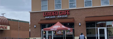 Exterior of Loaded Cafe with a large “LOADED CAFE” sign and “Pancakes • Burgers” below it on a brick storefront.