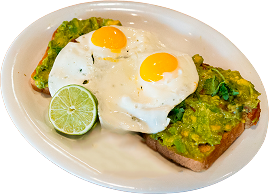 A plate of avocado toast topped with two fried eggs and a lime wedge on the side.