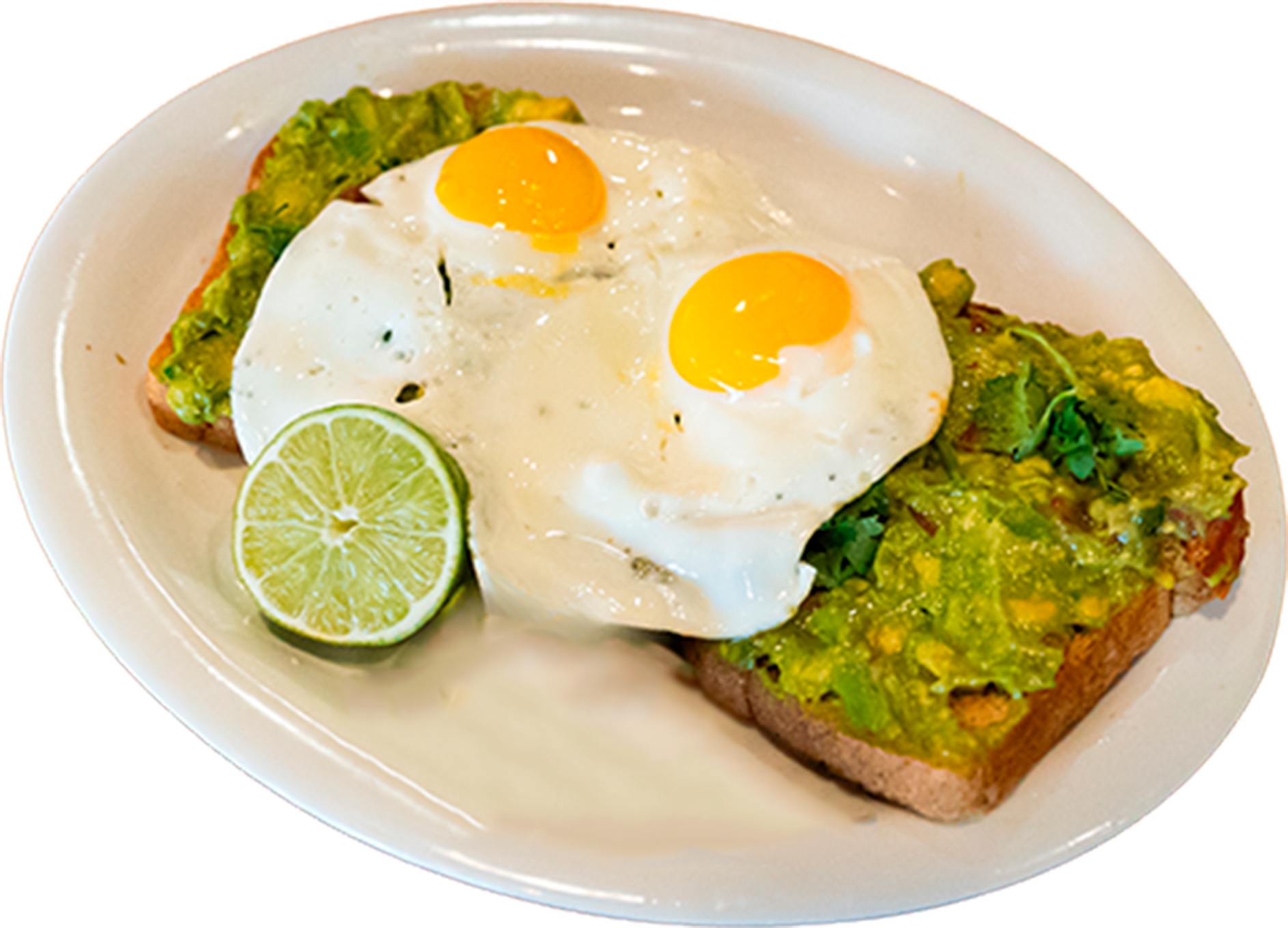 A plate of avocado toast topped with two fried eggs and a lime wedge on the side.